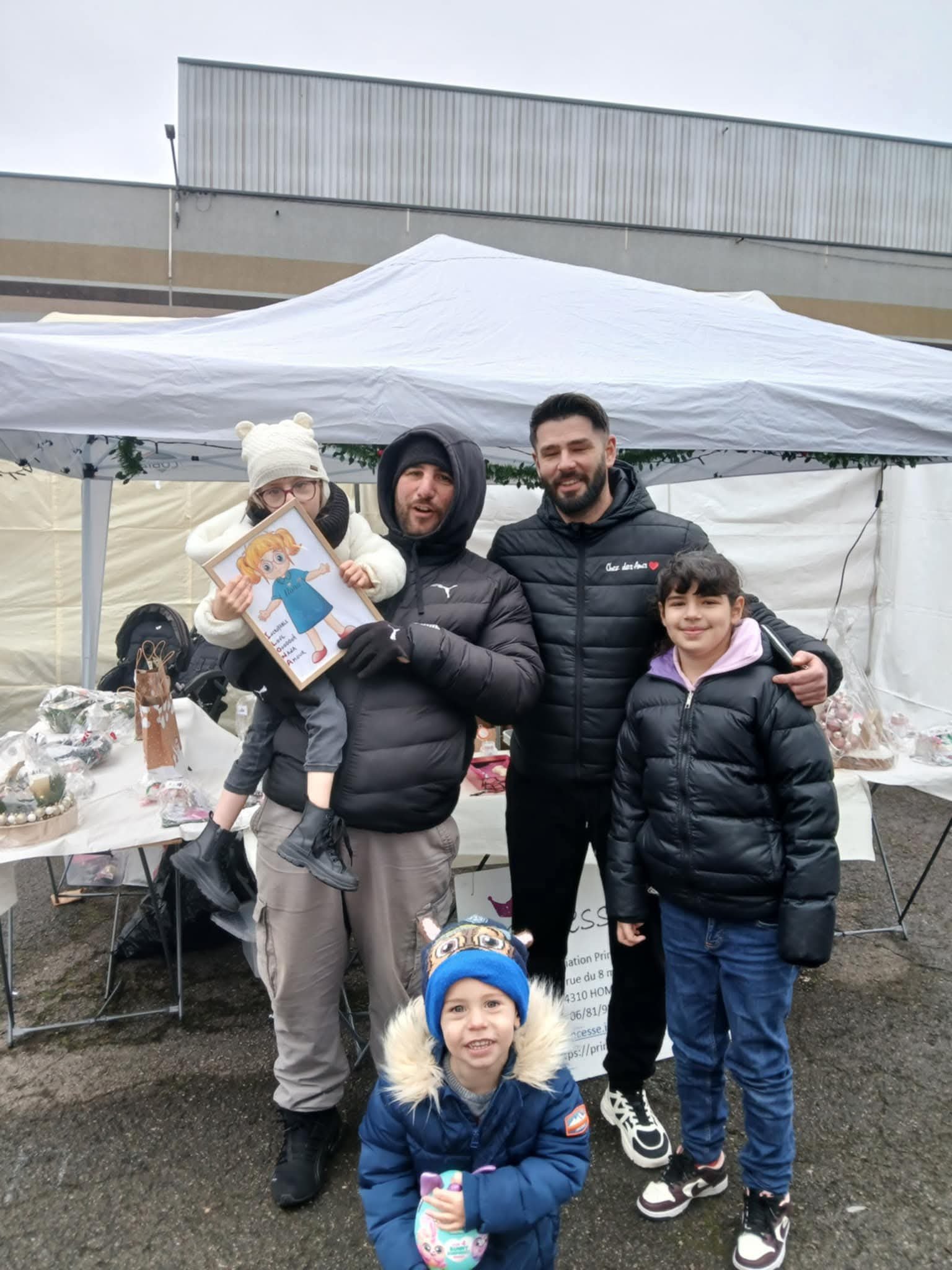 La famille d'Ilona sur un stand de marché avec son portrait